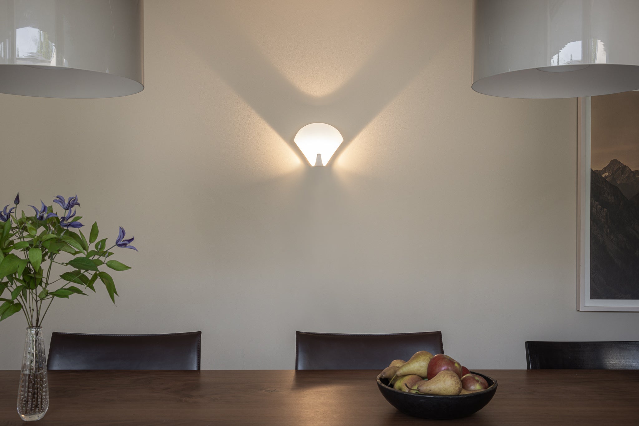 Peacock Wandleuchte in einem Esszimmer mit Tisch und Obstschale, schönes Lichtspiel des Wandskulptur