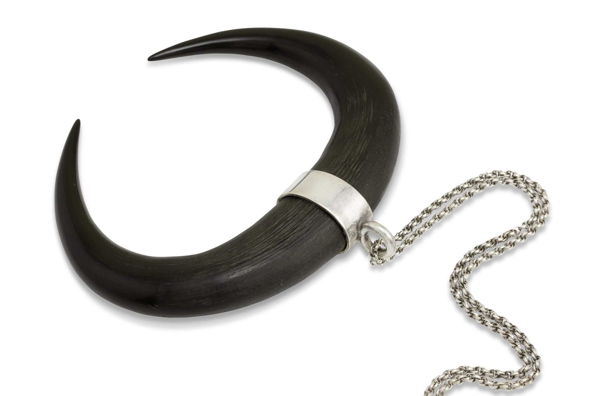 Die zwei polierten Spitzen von Gemshörnern, die durch ein Silberband zusammengehalten werden. Die Hörner formen ein Oval. 