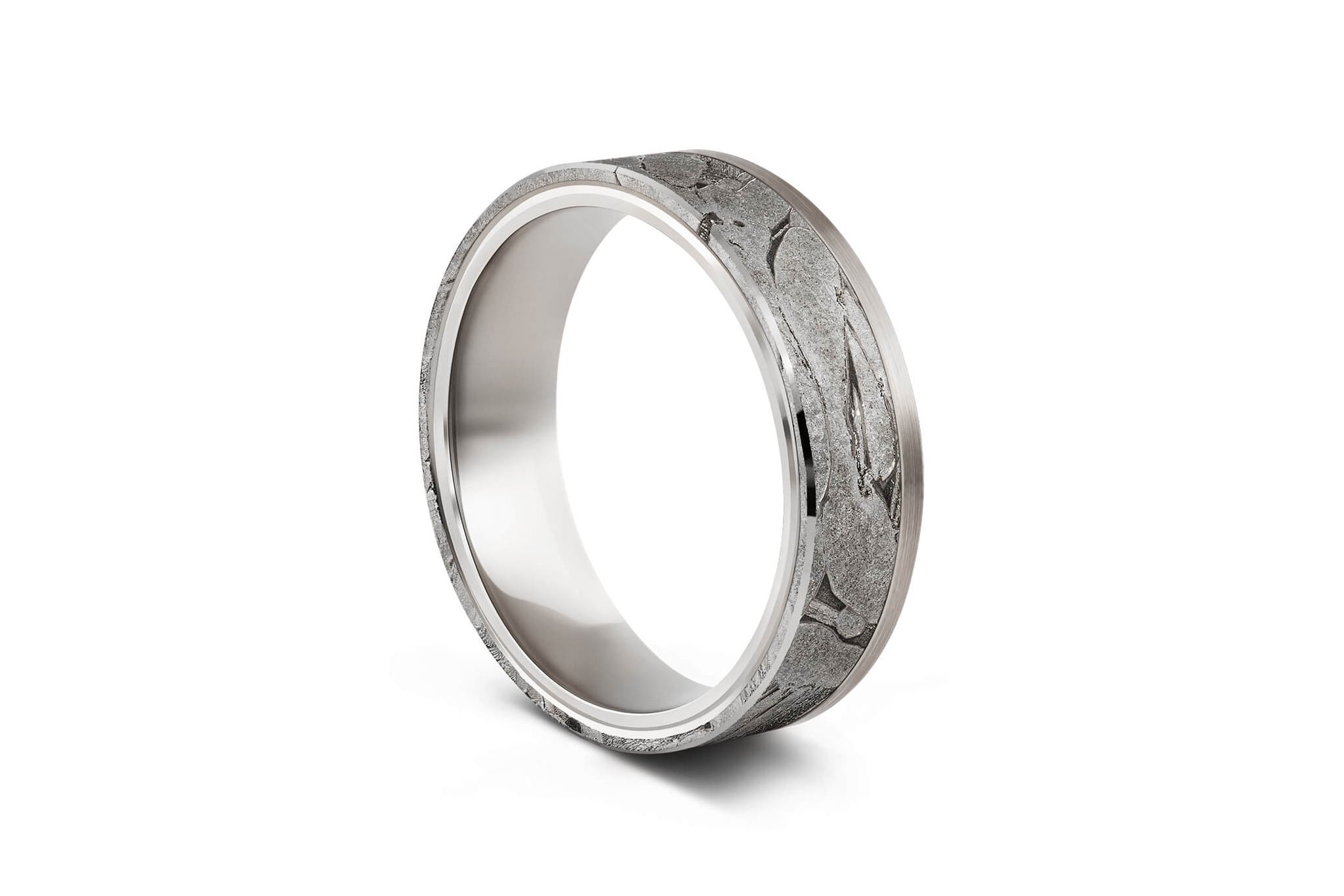 Breiter Ring aus Meteorit mit wunderschönem metallisch glänzenden Widmanstätten Muster. Innenseite aus Gold. Seitlich eckige Kanten. An einer Seite verläuft ein Silberband neben dem Meteoriten-Band. Seitlich aufgenommen.